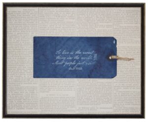 Navy tag with Oscar Wilde To Live quote on newsprint